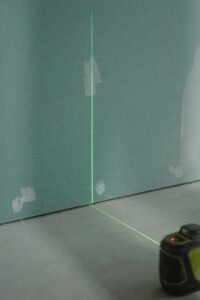Structural engineer using a laser level to detect foundation issues